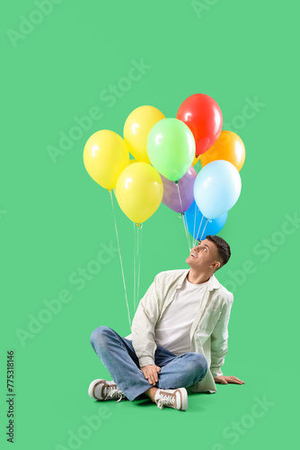 Happy young man sitting on ...