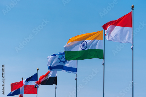 Flags against the blue sky. National flags of various countries flying in the wind. Flags of world states.