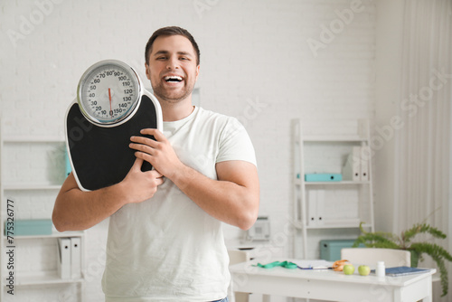 Young man with weight scale...