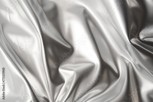 Silver foil texture abstract background. Textured crumpled metallic surface backdrop with light reflection. 