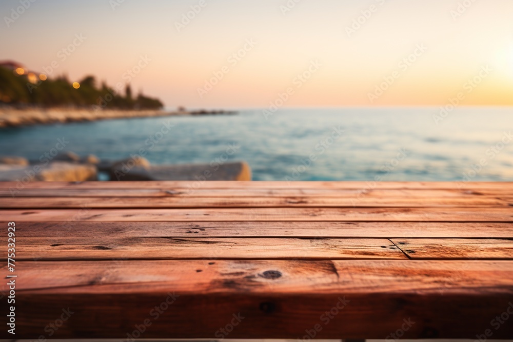 Empty wooden tabletop mockup for promotional items with blurred background and pink cloudy sky over calm sea
