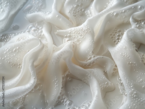 White fabric with detergent foam on it. Soaked fabric is folded in water, creating a unique and interesting design