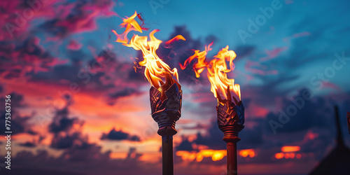 Hawaii luau party Maui fire tiki torches with open flames burning at sunset sky clouds at night © Oleksandr