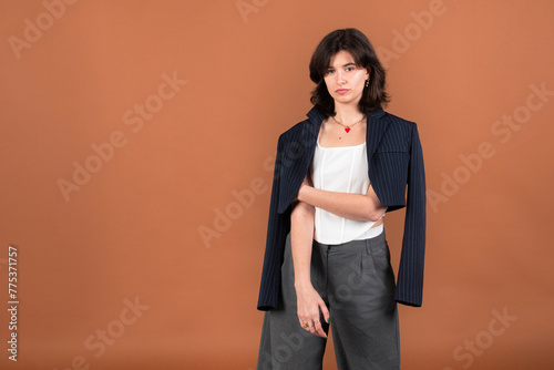 A woman posing with a jacket draped over her shoulders, exuding elegance and sophistication in her attire.