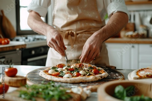 Expert chef garnishing pizza with fresh ingredients in a kitchen setting photo