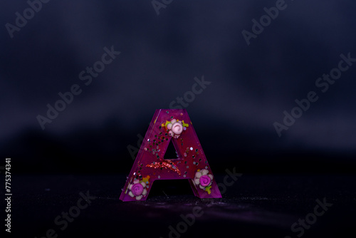 letra A com flores pequenas em fundo escuro photo