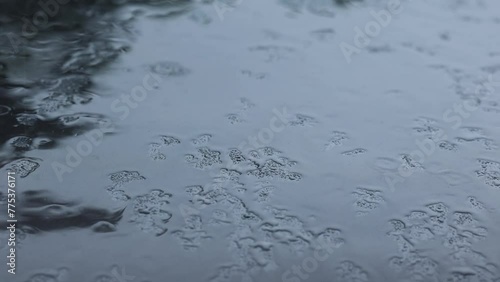 Raindrops Falling on Gray Metal Surface: Subtle Rainwater Close-Up