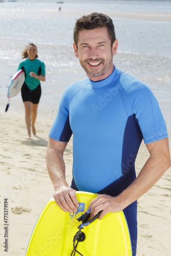 man holding a bodyboard at the beach photo