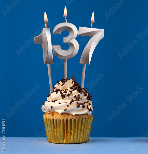 Vertical birthday card with cupcake - Lit candle number 137 on blue background