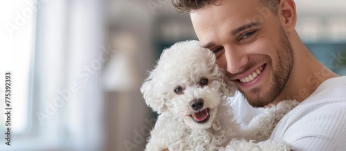 Man holding white dog in arms