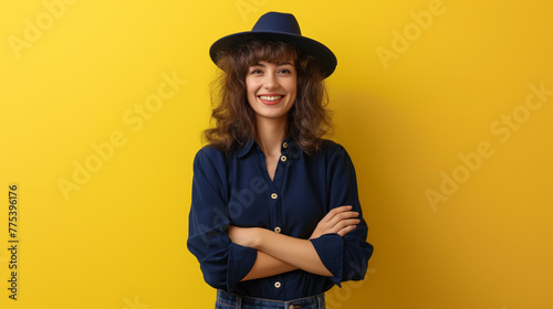 Mulher sorrindo de braços cruzados vestindo azul marinho no fundo amarelo