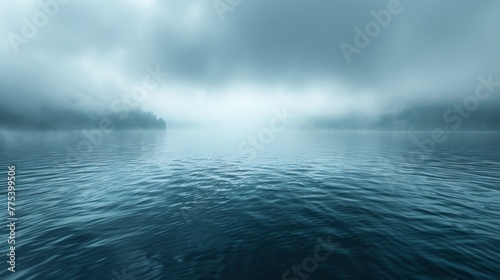   Large body of water in the distance  with forest and few clouds on a foggy day