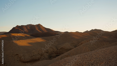 The first light of dawn gently illuminates Timna Valley, highlighting the smooth contours and soft colors of its serene desert landscape