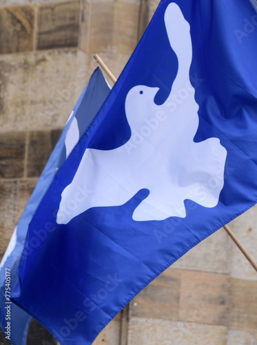 Im Wind wehende blaue Fahne mit weißer Friedenstaube