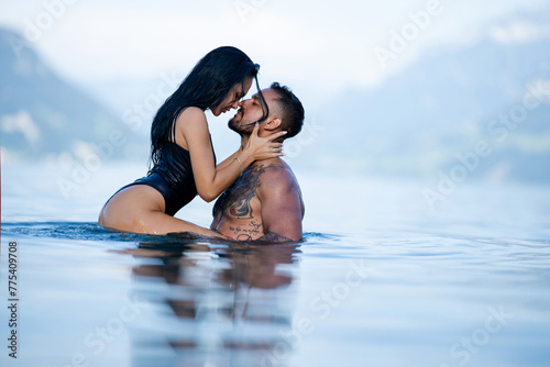 Summer sexy couples. Romantic couple in sea water. Beautiful young couple in love on the lake. Sexy couple kissing by the sea. Dream vacation. Embrace and kiss in the water. Romantic beach paradise.