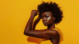 Black fitness girl in powerful dynamic posture against a yellow background. Concept for wellness campaigns and motivational content.