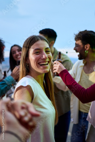 Vertical. POV young smiling Caucasian woman holding hands boyfriend at party. Attractive girl looking cheerful on camera friends in background outdoors. People gathered on rooftop celebrating birthday
