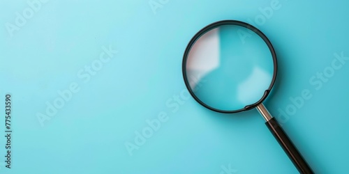 A magnifying glass is on a blue background. Concept of curiosity and exploration photo