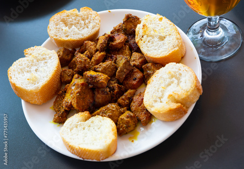 Pinchos morunos, roasted slice meat served with baguette in a restaurant photo