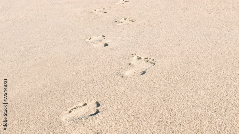 Footprints in the sand on the beach. The camera follows footprints in a large sand dune on the background of beach. 4k resolution video of footprint and sand Footprints in the sand on the beach. The camera follows footprints in a large sand dune on the background of beach. 4k resolution video of footprint and sand