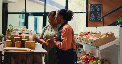 Fotografi Merchant presenting homemade sauces and spices to client, promoting local farming and healthy eating