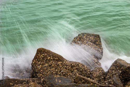Waves photographed at low speed breaking on the rocks