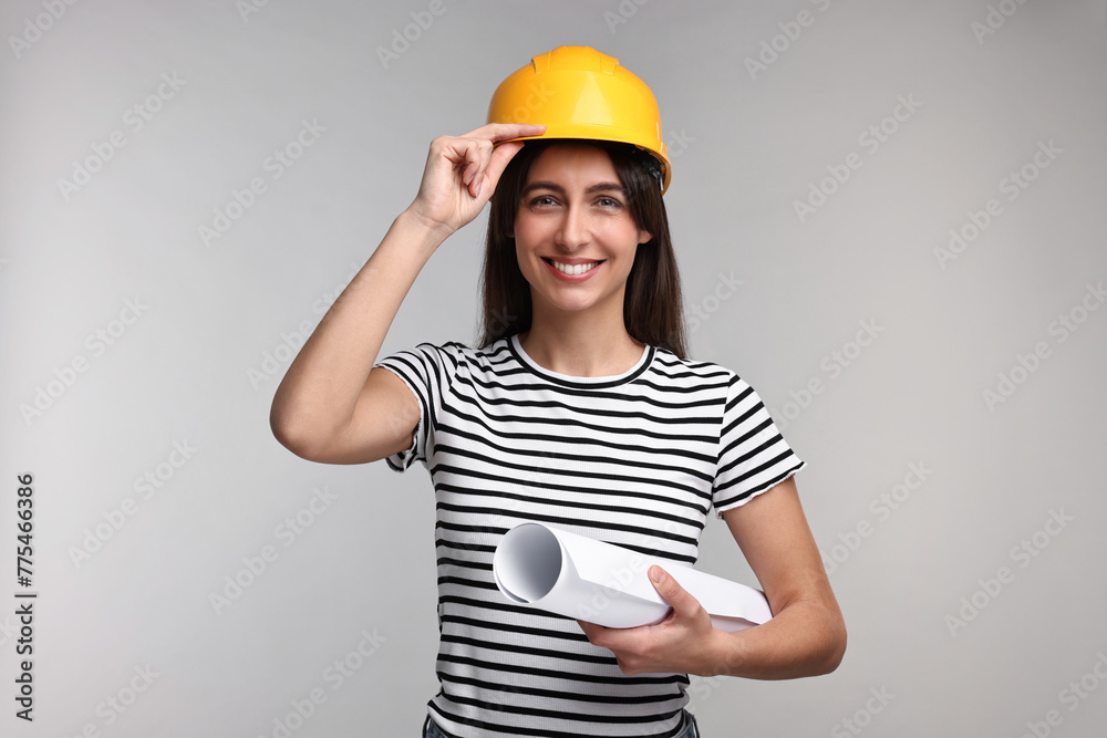 Architect with hard hat and draft on light grey background