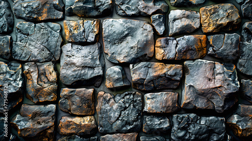 A wall of interlocking natural stones in varying shades of grey and brown, creating a rugged, textured surface.