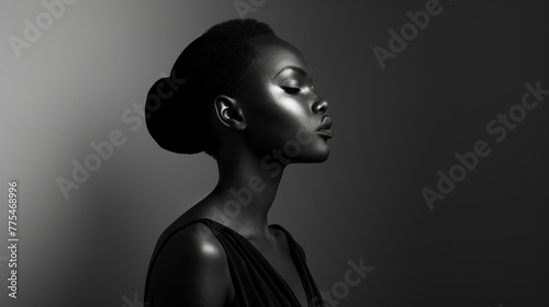 In a classic black and white portrait a poised black woman embraces the elegance of timeless fashion. The monochrome tones draw attention to the fine details and clean lines of her . photo