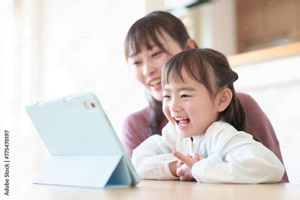 タブレットを楽しむ女の子とお母さん タブレットを楽しむ女の子とお母さん