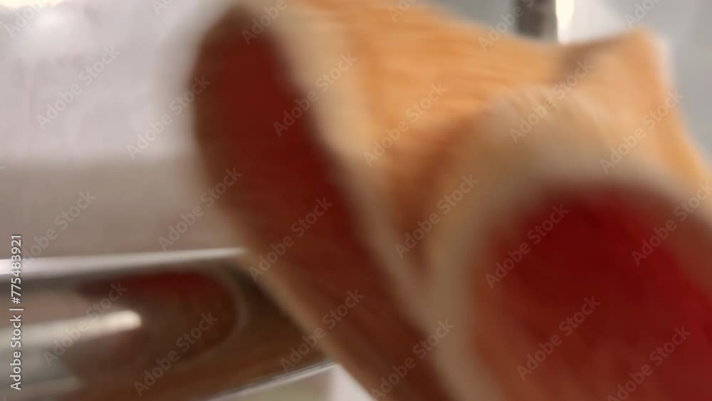 Functional Design Meets Homely Comfort in This Close-Up: A Man's Hand Retrieves a Dry Orange Towel from a Heated Chrome Towel Rail in a Stylish Bathroom