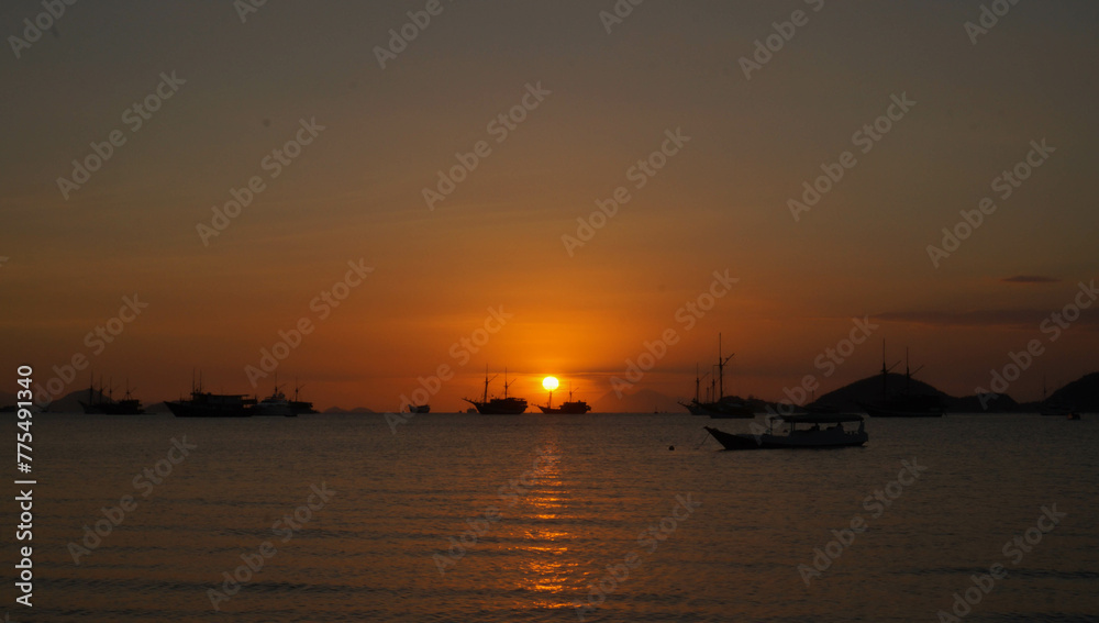 View of the sunset with the silhouettes of ships in the distance