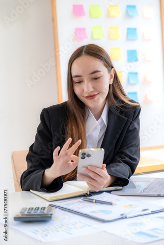 Successful businesswoman financier investors use smartphone to communicate remotely over the internet or video call to set challenging business goals and ready to achieve targets from work office