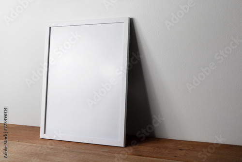 Minimalist mockup poster white frame laying on the wooden table