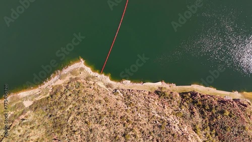 4k drone video of green mounting river in the summer time. Day time of dam river top view crossing the water. photo