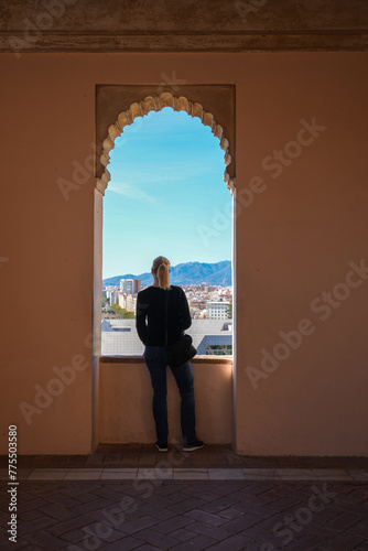 Woman looking out window in Alcazaba in Malaga Spain