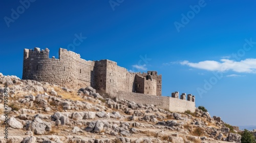 Ancient stone castle structure on a high surface against a clear sky.  © CStock
