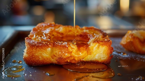 A thick slice of deep-fried brioche  puffed up and golden  ready to be drizzled with honey