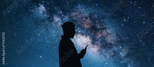 Man with cellphone under starry sky