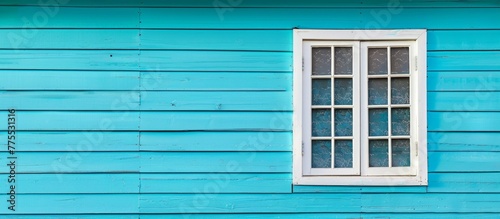 A blue house with a white window and a white window