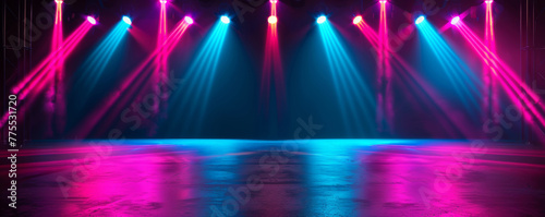 Neon blue and pink spotlights illuminate empty textured stage floor