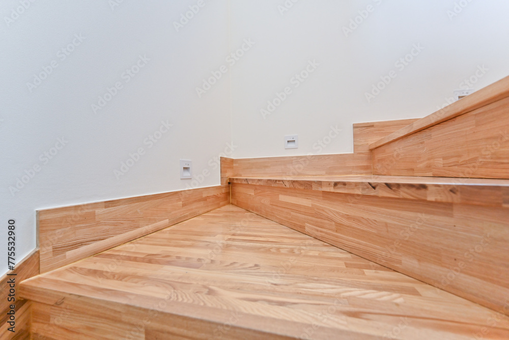 A bright wooden colored staircase that matches a clean and pretty interior