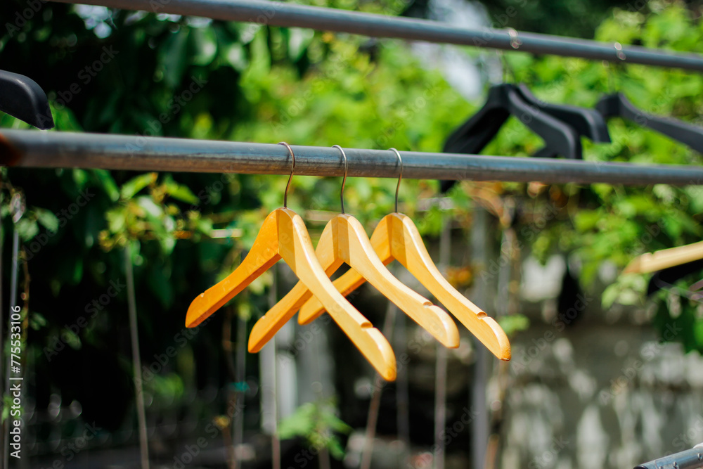 wooden clothes hanger with a natural leafy background in the garden wooden clothes hanger with a natural leafy background in the garden