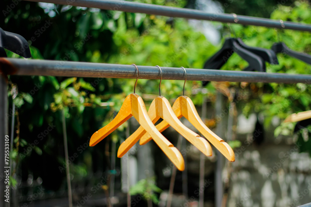 wooden clothes hanger with a natural leafy background in the garden wooden clothes hanger with a natural leafy background in the garden