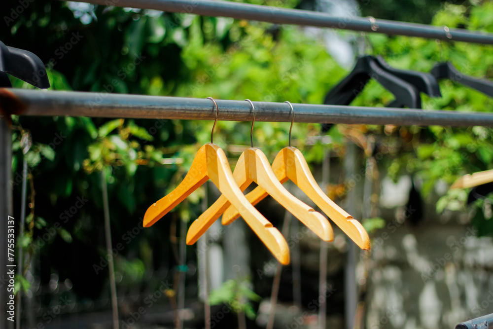 wooden clothes hanger with a natural leafy background in the garden wooden clothes hanger with a natural leafy background in the garden