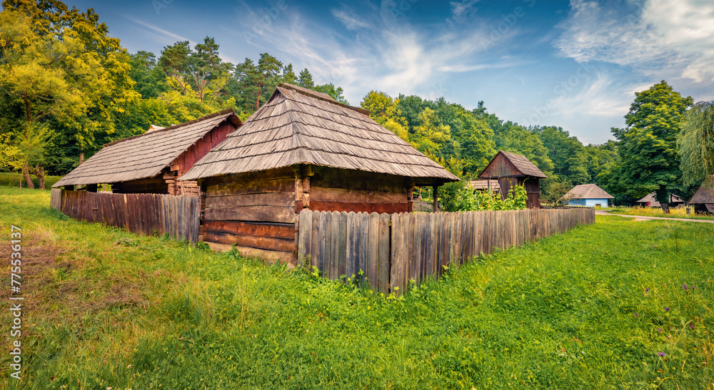 Obraz premium Marvelous summer view of traditional romanian wooden peasant houses. Colorful rural scene of Transylvania, Romania, Europe. Beauty of countryside concept background..