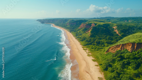 An aerial view of the sandy beach on one side, overlooking green hills and cliffs leading to an ocean with gentle waves. A stunning coastal scene with clear blue waters, golden sand, lush vegetation.