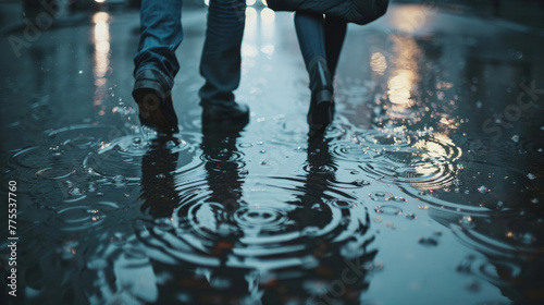 A couple walks hand in hand through the rainsoaked streets their footsteps causing small ripples in the puddles beneath them. In the . .