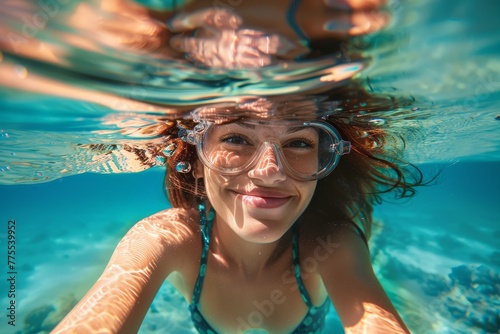 Happy girl underwater with goggles, bubbly and bright