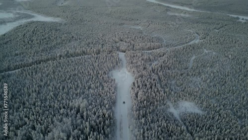 Drone footage captures a black van moving through a snow-covered forest in Luosto, Finland, near the Arctic Circle, as it descends. photo